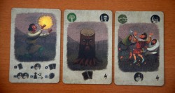 Z lewej - karta darów losu (gracz rzuca tyloma kostkami ilu jest graczy, wybiera jedną kostkę i odpowiadającą jej nagrodę, pozostałe kostki przekazuje innym graczom - każdy dostanie nagrodę) oraz dwie karty wyzwań z efektem natychmiastowym